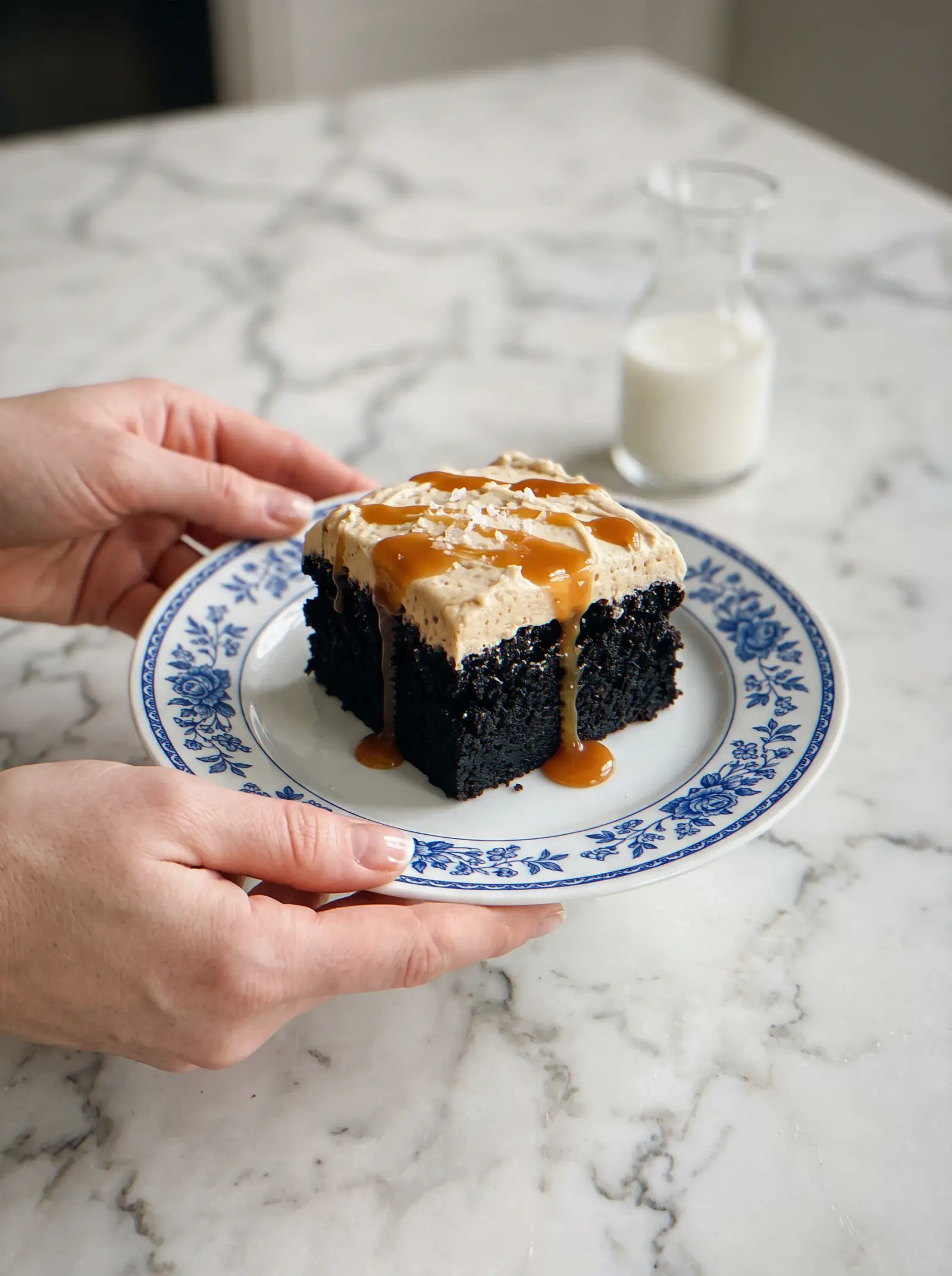 Slice of molten chocolate sticky toffee pudding cake on a plate with extra toffee caramel sauce and sea salt
